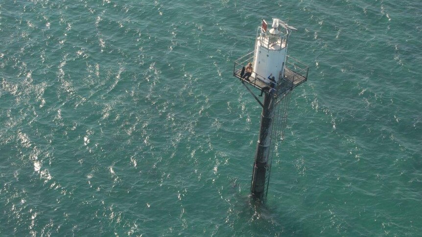 Two fishermen wait for rescue on the navigation mast in waters off the NT coast
