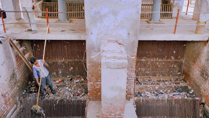 A man works at a sewage treatment plant in India.