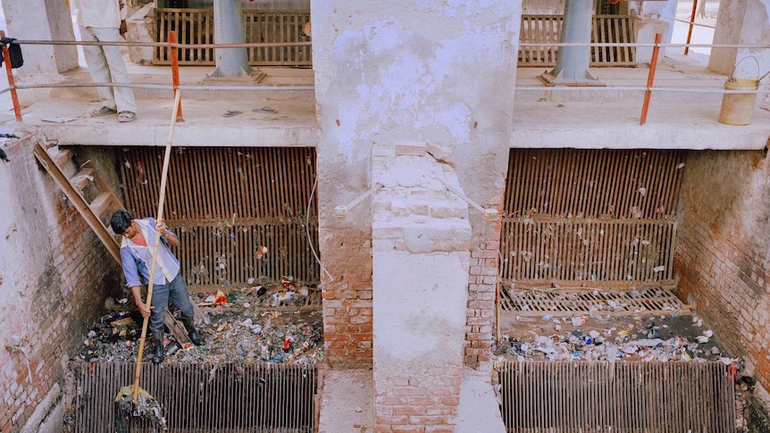 A man works at a sewage treatment plant in India.