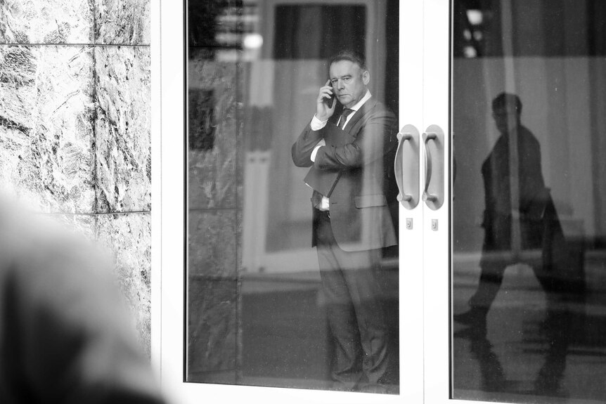 Joel Fitzgibbon looks out the window while speaking on his mobile phone