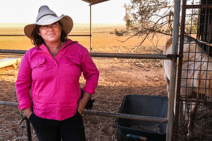 A woman wearing a hat on a farm.