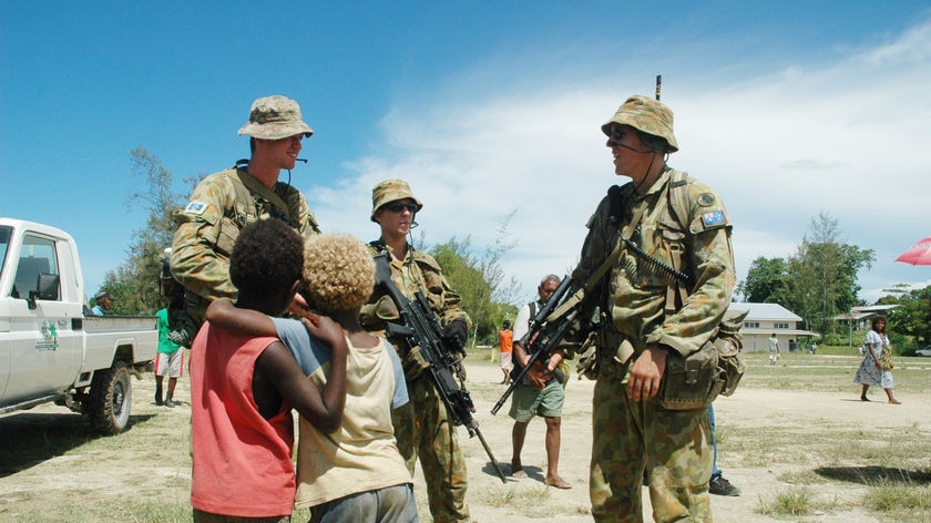 Australian peacekeeping soldiers talk to children in the Solomon Islands.