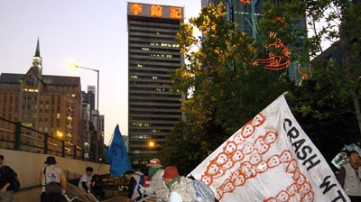 Anti-globalisation demonstrators overthrow crowd-control barriers during a demonstration.