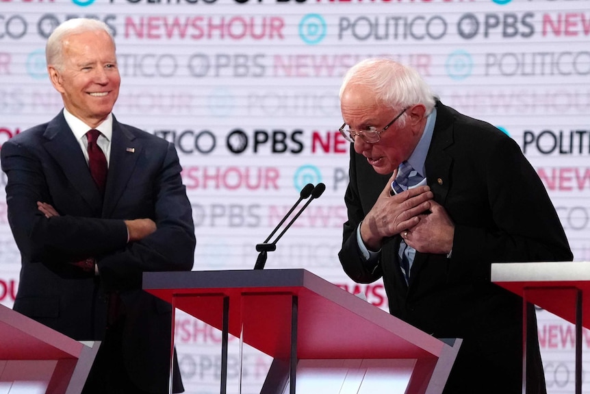 Former Vice President Joe Biden watches and listens to Senator Bernie Sanders speak