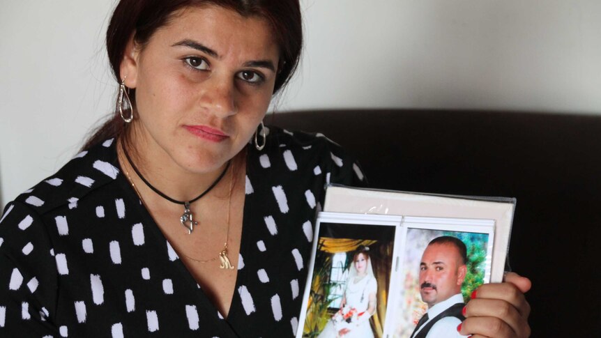 Hayfa Adi holds a photo of herself and her husband Ghazi on their wedding day
