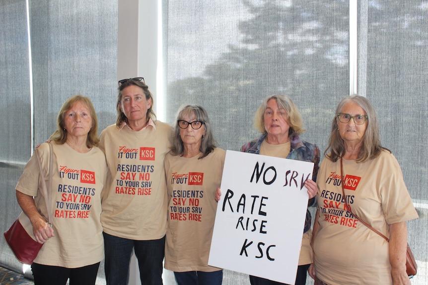 Four women wearing t-shirts and one holding a sign in opposition of rate rises
