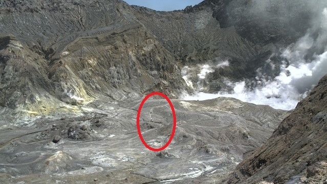 A red circle around a group of people seen in a volcanic crater before it erupted.