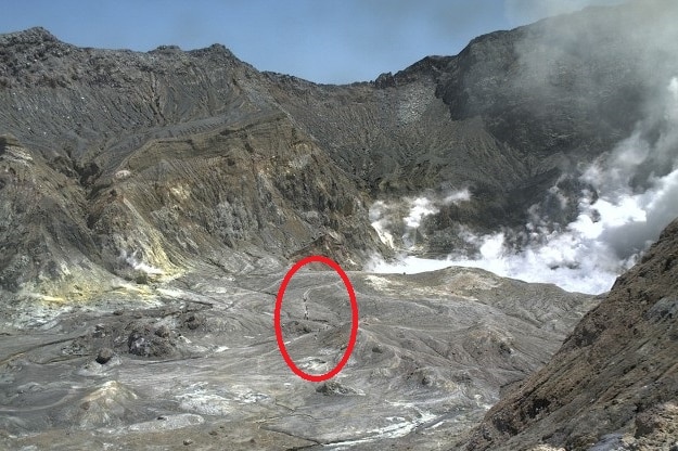 A red circle around a group of people seen in a volcanic crater before it erupted.