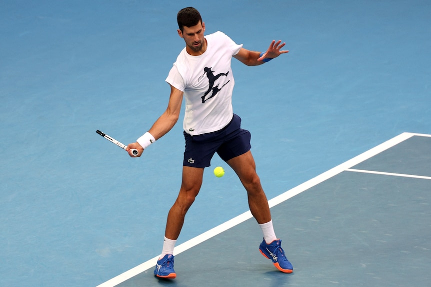 A man hits a forehand on a tennis court.