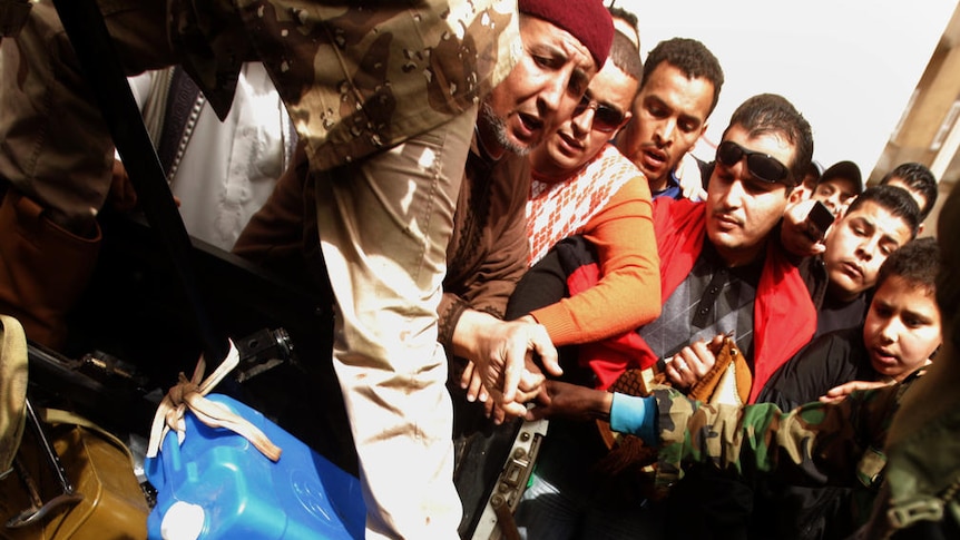 An injured member of Gaddafi's forces is paraded through Benghazi after his capture.