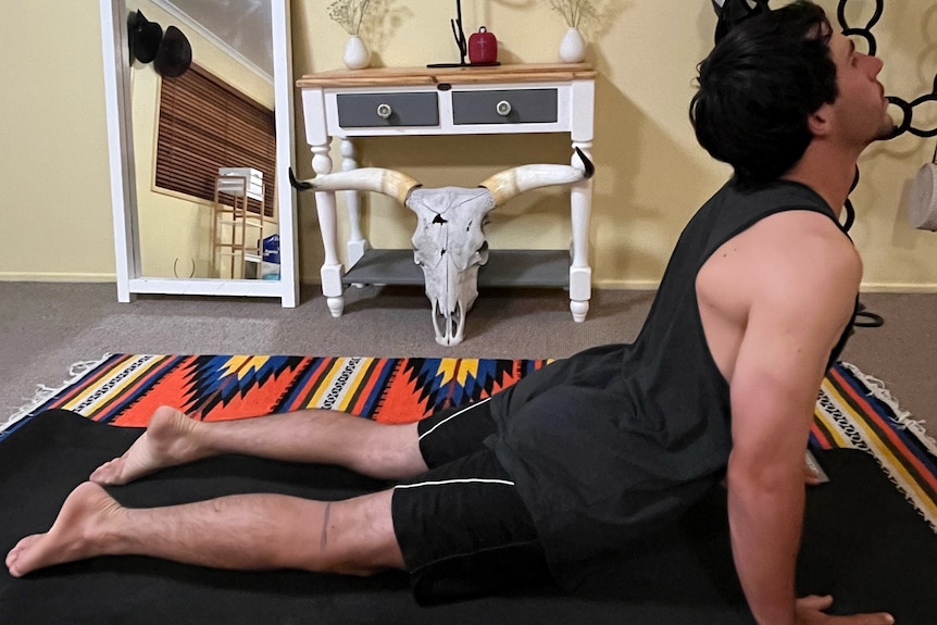 Man on his stomach pushing his head upwards in a yoga pose