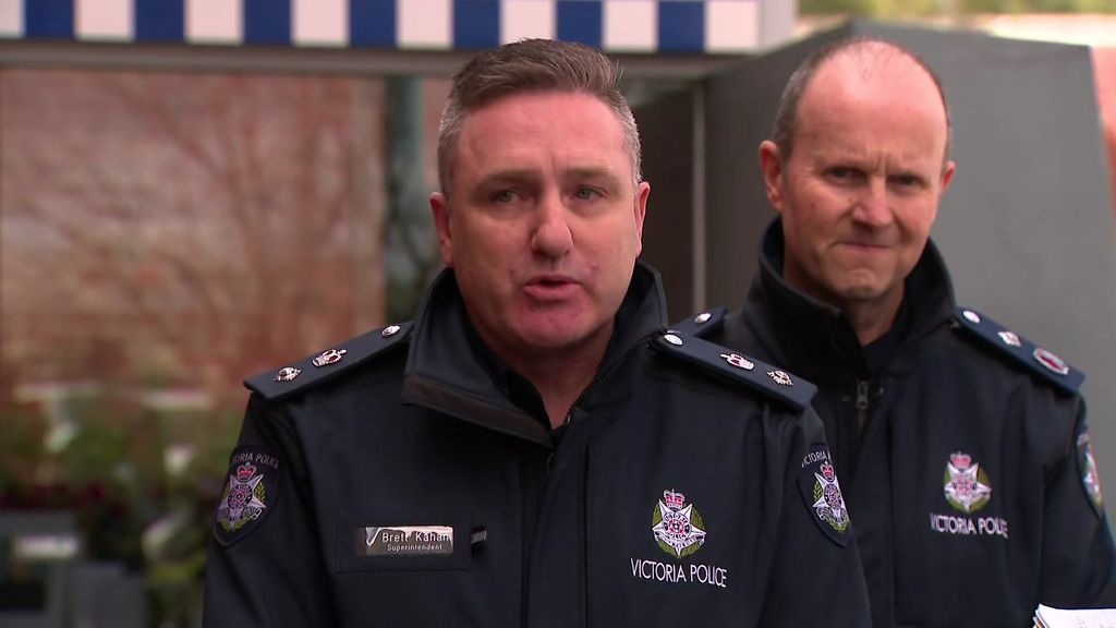Two Victoria Police officers in uniform address the media outside Wangaratta police station.