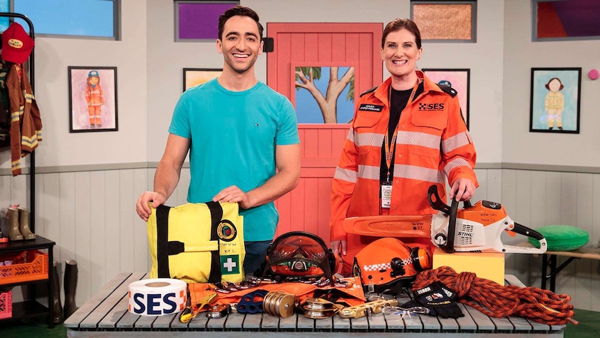 Matt with Mara from the SES standing behind a table which has equipment used by the SES on it.