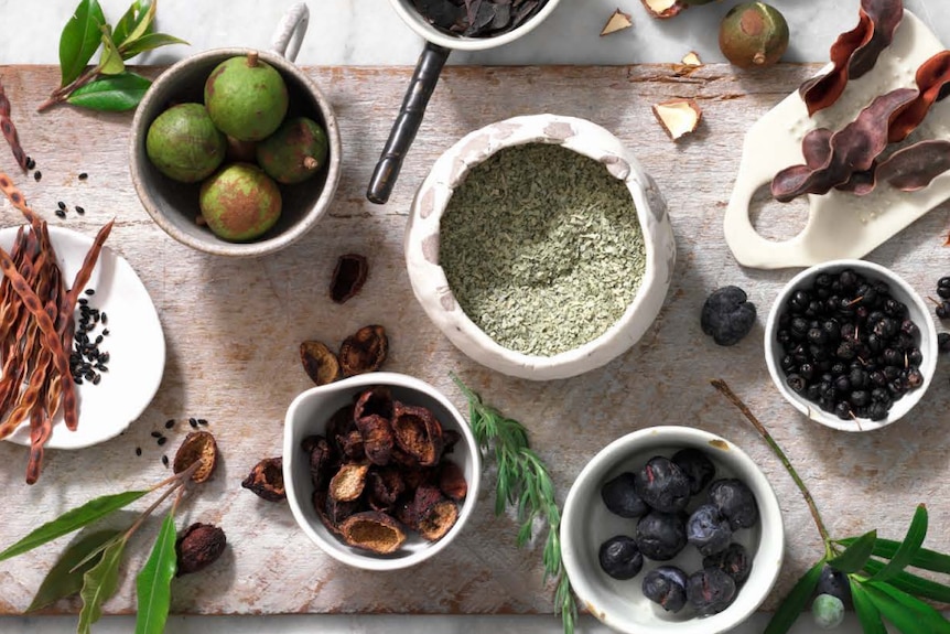 Native ingredients laid out on a chopping board;  salt bush, wattle seed and lemon myrtle.