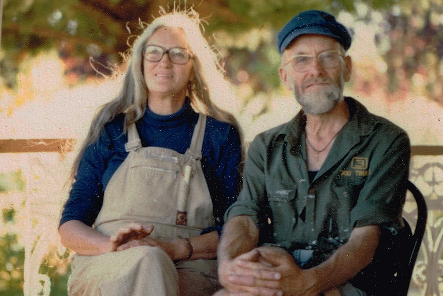 Kathleen Golder and Peter sit on their verandah, with trees behind them, Tasmania, supplied.