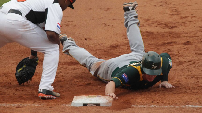 Aussies outclassed ... James Beresford slides into first base in the sixth inning.