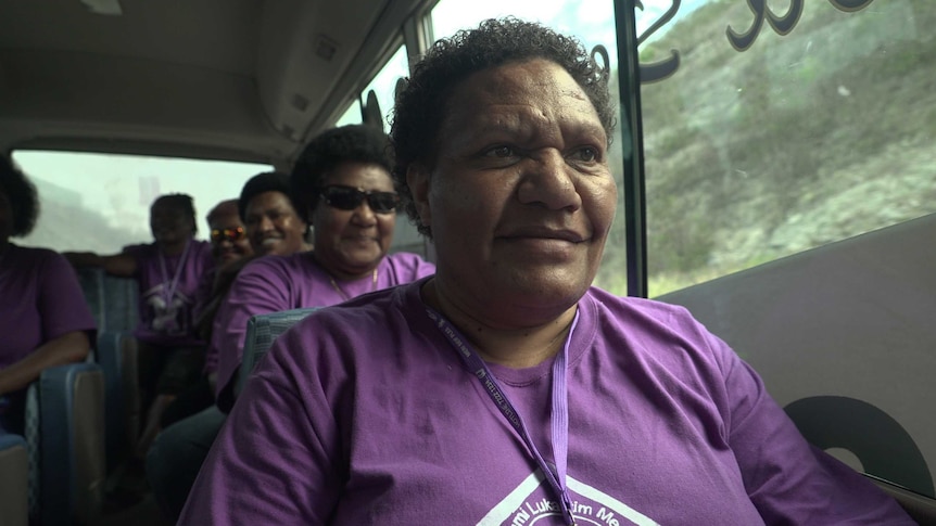 Close up image of Christina Memti in a purple shirt in a bus with four other women from the Meri Seif program