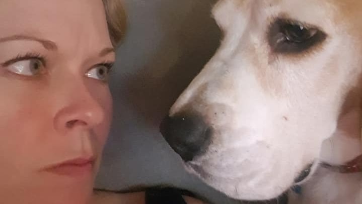 A woman and a dog look at each other