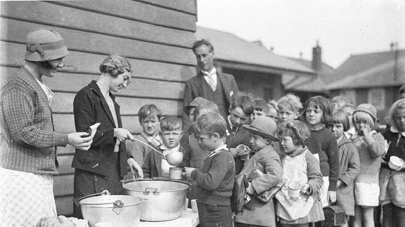 Children queue for soup and bread during the Great Depression, circa 1932.