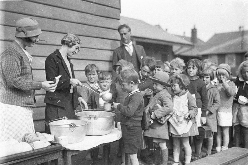 Children queue for soup and bread during the Great Depression, circa 1932.