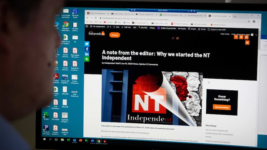 Christopher Walsh sits at a computer screen which shows web browser with an NT Independent article loaded.