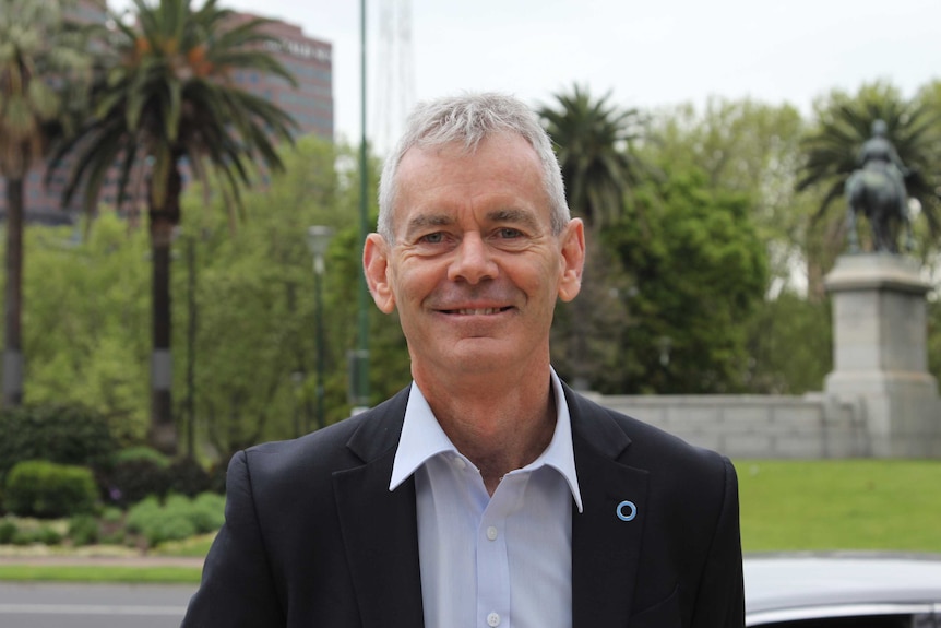 Greg Johnson looks at the camera while standing in Melbourne's Royal Botanic Gardens.