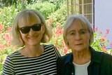 A picture of a woman with blonde hair and sunglasses standing next to her mother with grey hair.,