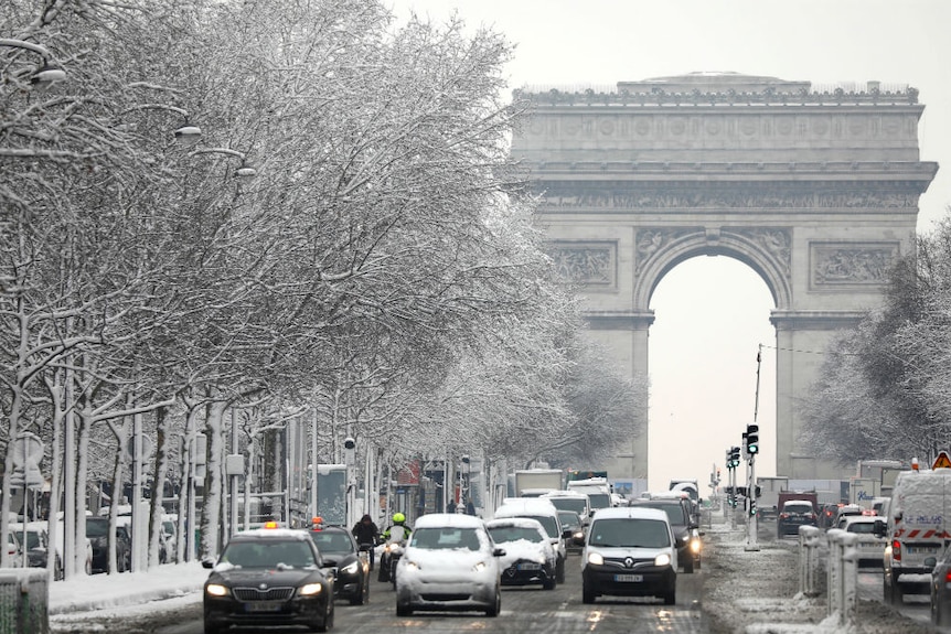 the snow-covered Champs-Elysees avenue below the Arc de Triomphe in Paris