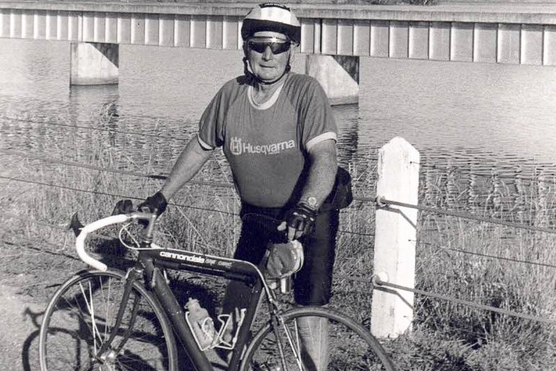 A man standing next to a bicycle.