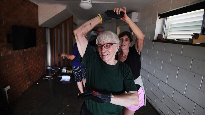 Ms Peatling dances with friends who helped her clean up her flooded Townsville home.