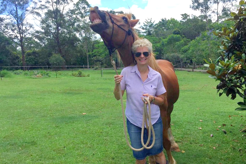 Woman stands with horse that looks like its smiling