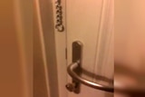 An apartment door handle is seen in a screenshot from a video taken inside the burning building