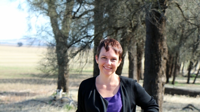 Agriculture Minister Jaala Pulford standing in a paddock in front of some trees.