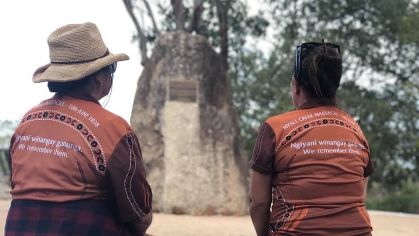 Two women with their backs to the camera in front of the Myall Creek Massacre and Memorial Site.