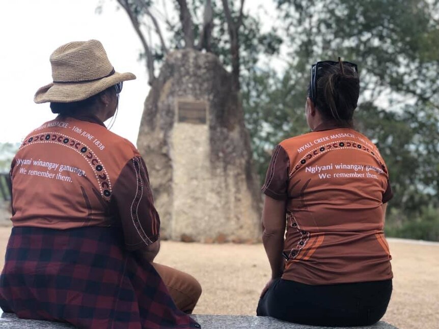 Two women with their backs to the camera in front of the Myall Creek Massacre and Memorial Site.