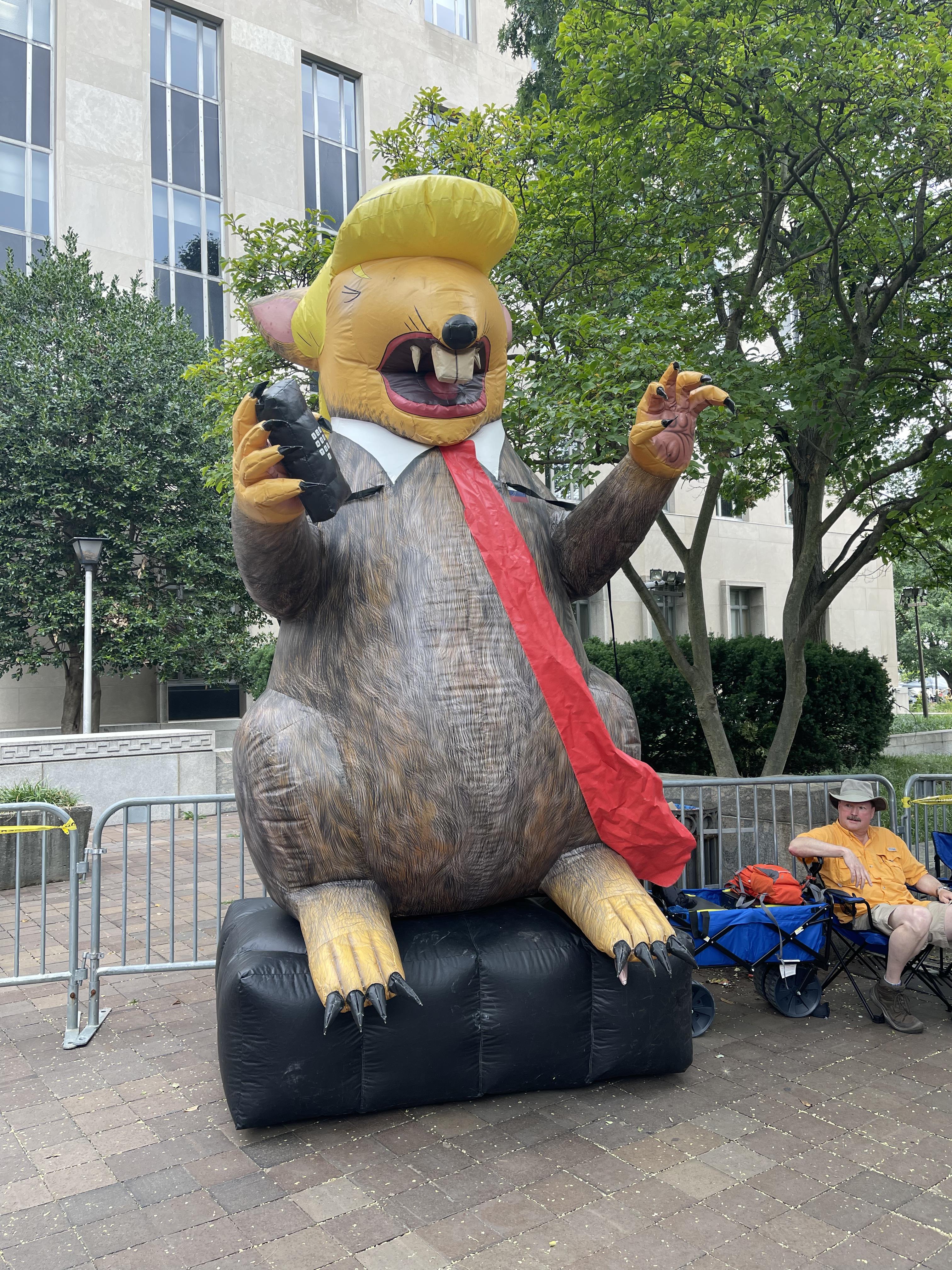Blown up rat looking like trump with tie and blonde hair 