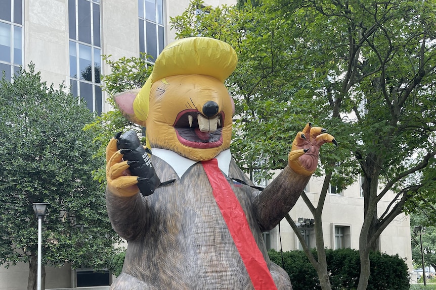 Blown up rat looking like trump with tie and blonde hair 