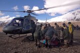 A survivor of a snow storm is assisted into a helicopter in Nepal.