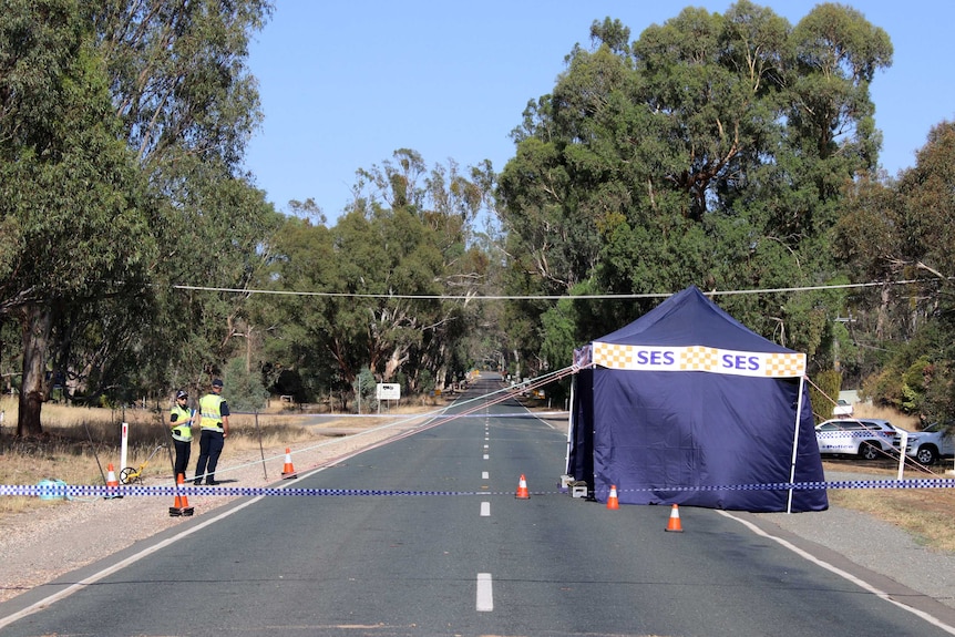 Police officers and a police tent on the road near Murchison.