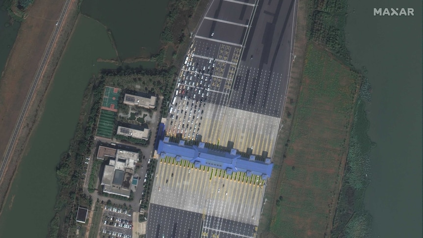 Satellite imagery shows a queue of cars at a toll gate in Wuhan, China.