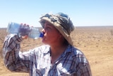 Grazier Anne Webber rehydrates amid the relentless heat on her Longreach property