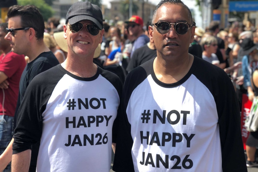 Two protesters in Melbourne wear t-shirts saying "Not happy Jan 26".