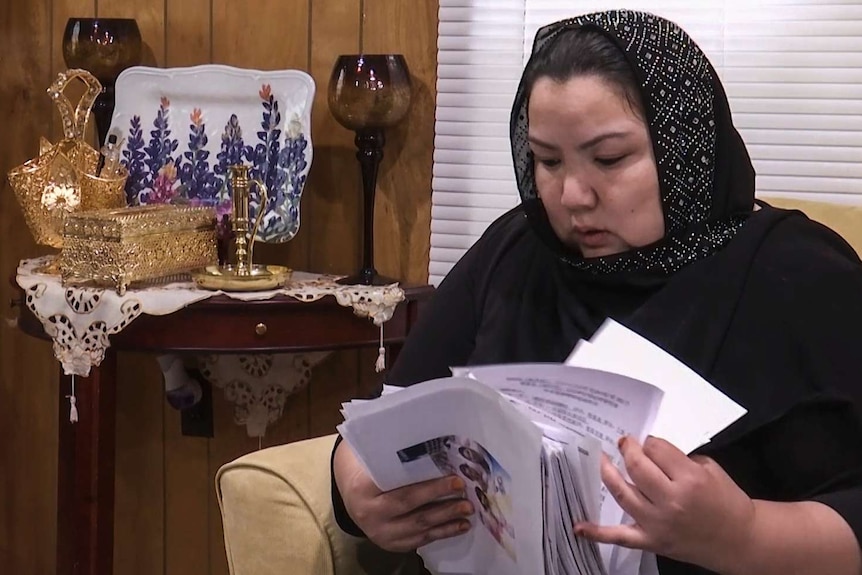 Zumret Dawut holds documents she brought with her from China.