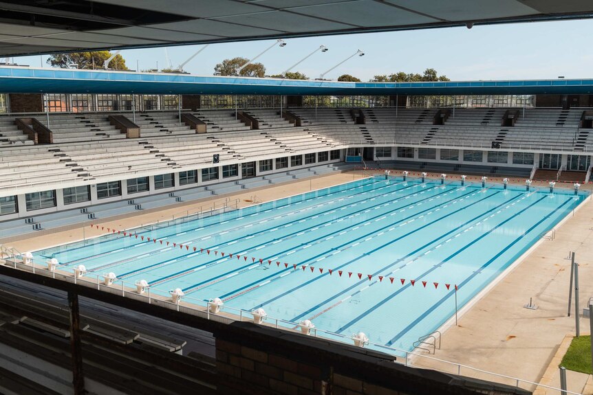 An empty swimming pool with grandstands surrounding it