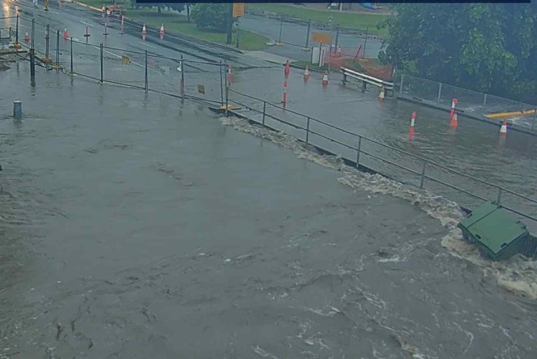 CCTV footage of water flowing onto a road and an industrial bin floating.