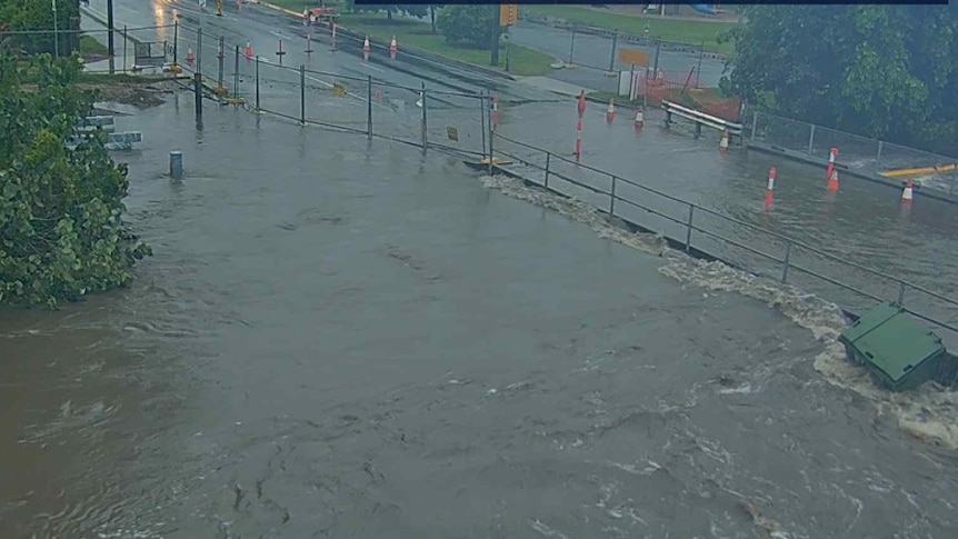 CCTV footage of water flowing onto a road and an industrial bin floating.