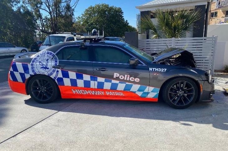 A dark coloured police car with the front smashed