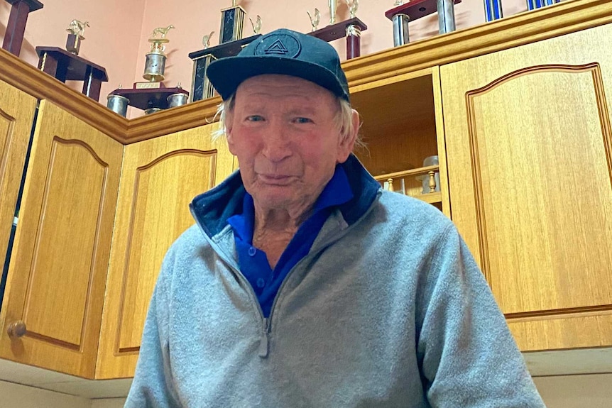 Man wearing grey jumper and black hat