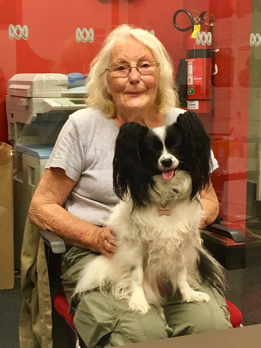 Lady with a dog on her lap smiling at camera