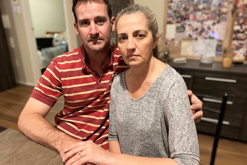 Brett Halford and Kerri Brown sit at a table holding hands in their house at Ipswich, west of Brisbane, on September 12, 2019.